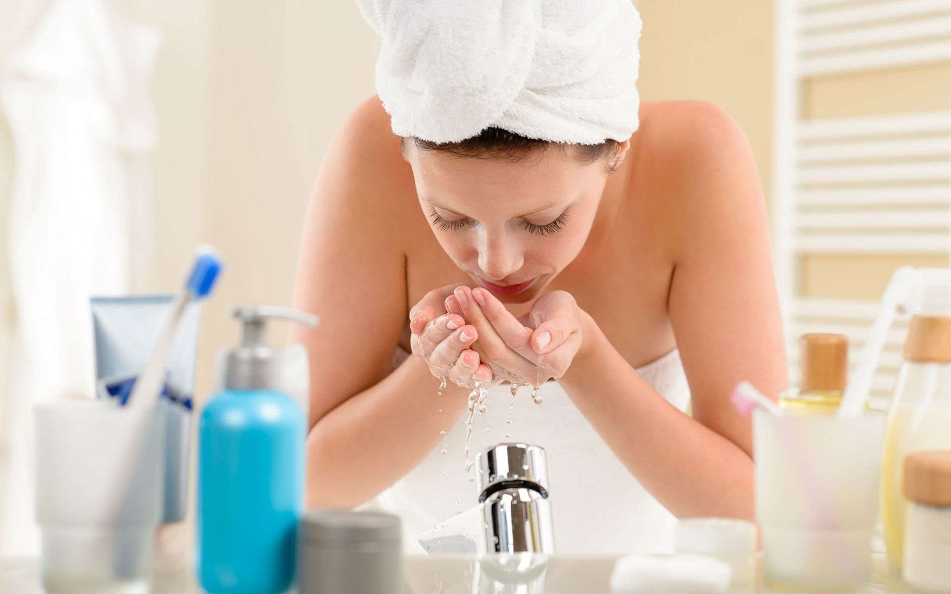 women relieving dry skin in bathroom with moisturizer