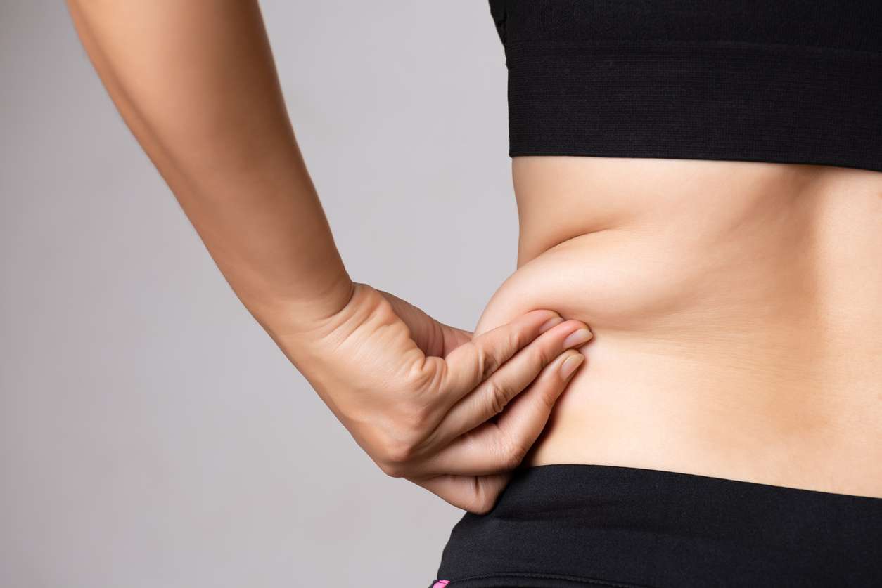 women pinching love handles and excess fat